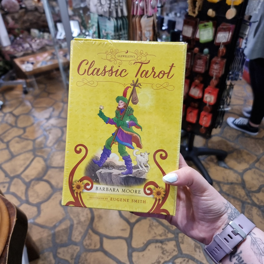 Hand holding a boxed Llewellyn's Classic Tarot deck inside the Rivendell shop
