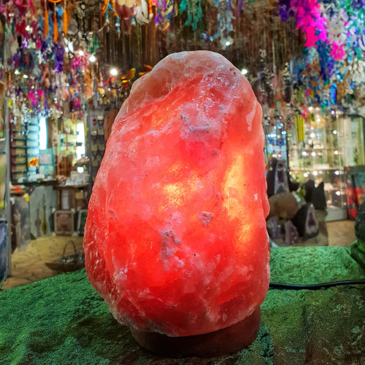 Himalayan salt lamp glowing warm orange in the shop, with colourful hanging decorations behind