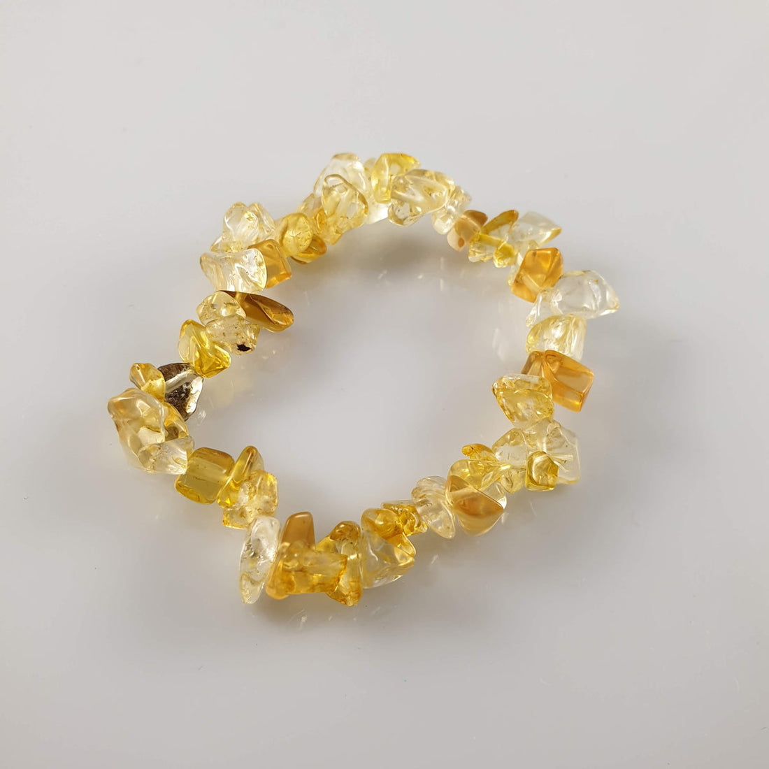 Citrine chip bracelet with golden yellow and honey-orange chips on a white surface