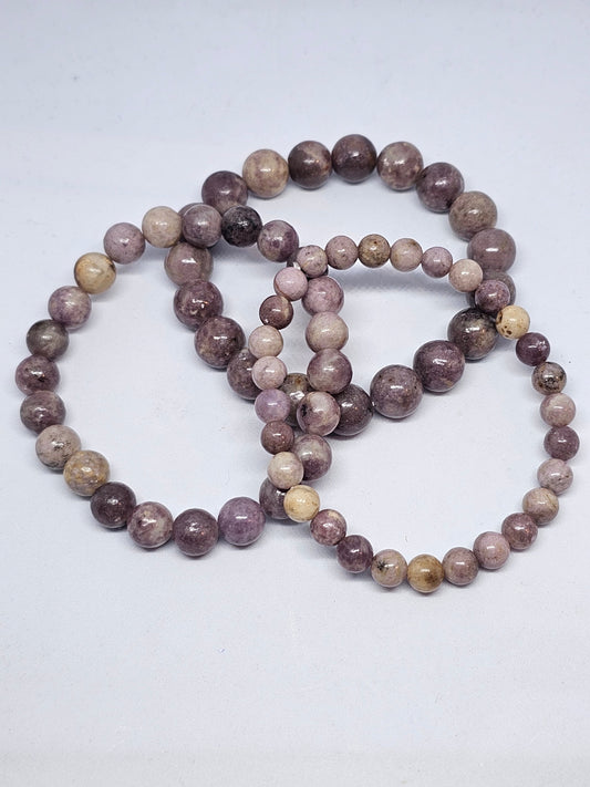 Pale violet lepidolite bead bracelets on a white background