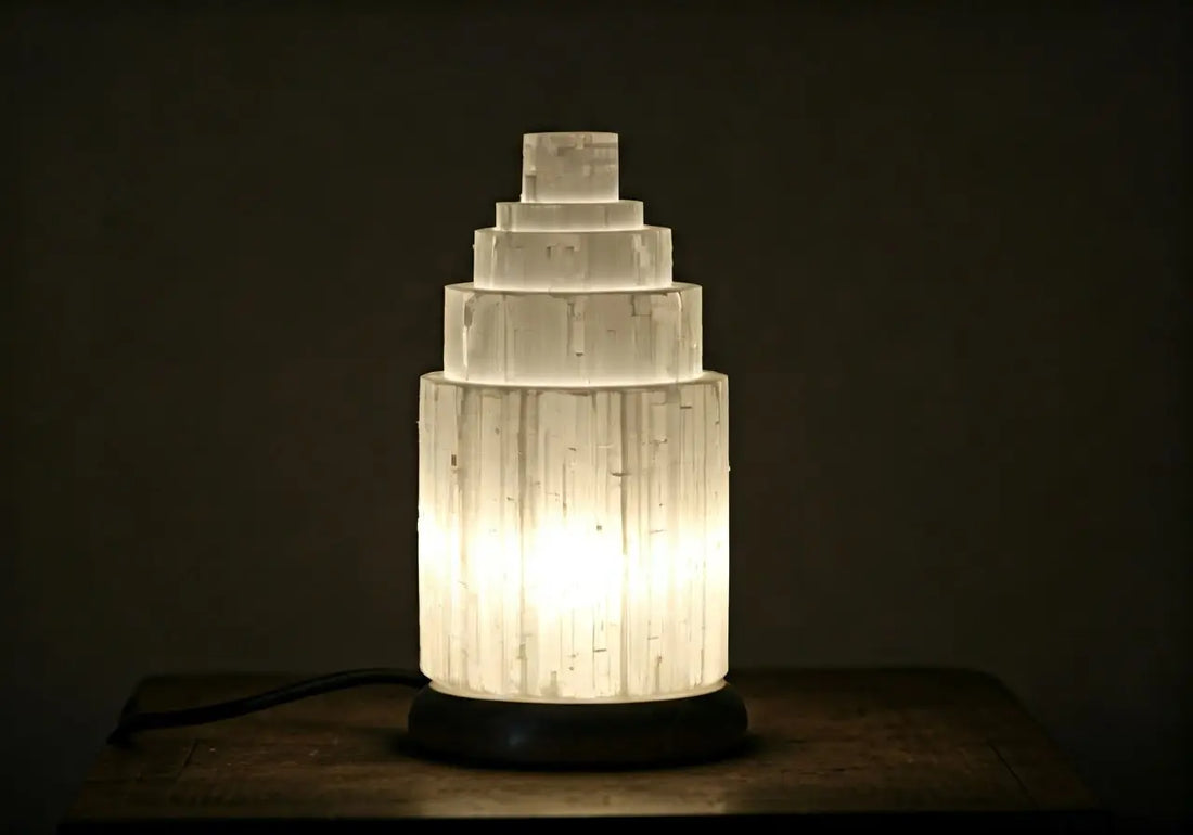 Glowing white selenite lamp tower on a wooden table