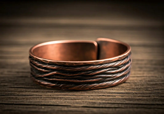 Close-up of a copper bracelet resting on a wooden table