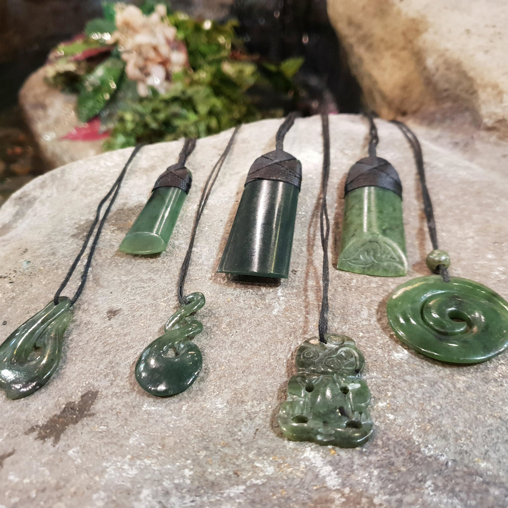 Several photographed greenstone carvings in distinct pendant shapes