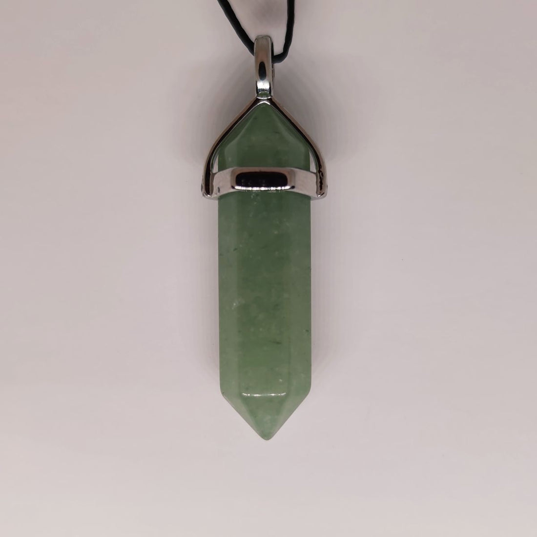 Green aventurine crystal point pendant on a cord, soft green with a gentle sparkle