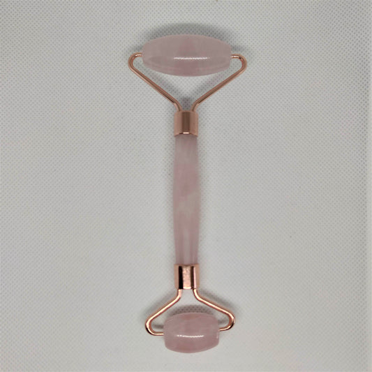 Rose quartz crystal face roller with two smooth pink stone ends