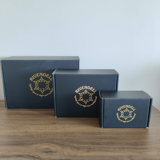 Three black Rivendell gift boxes with the gold Rivendell emblem, in small, medium and large