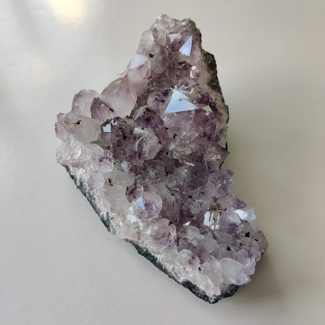 A natural purple amethyst crystal piece, a classic calming stone to keep on a bedroom nightstand for restful nights