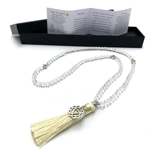 Clear quartz mala of 108 beads with a silver solar plexus chakra charm and cream tassel, in front of its gift box