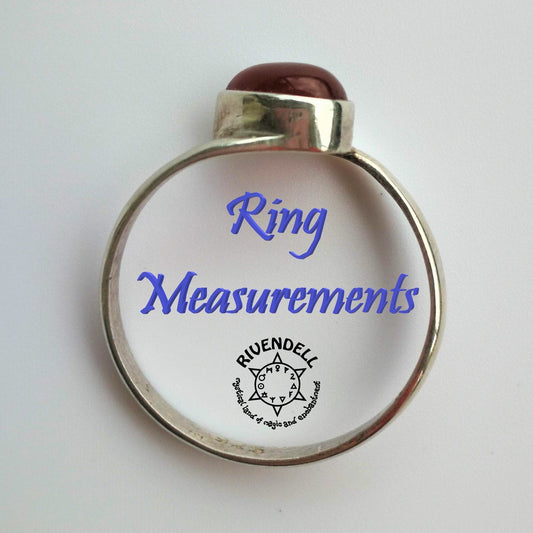 Sterling silver ring with a dark red cabochon stone standing on a white surface, with the words Ring Measurements inside the band