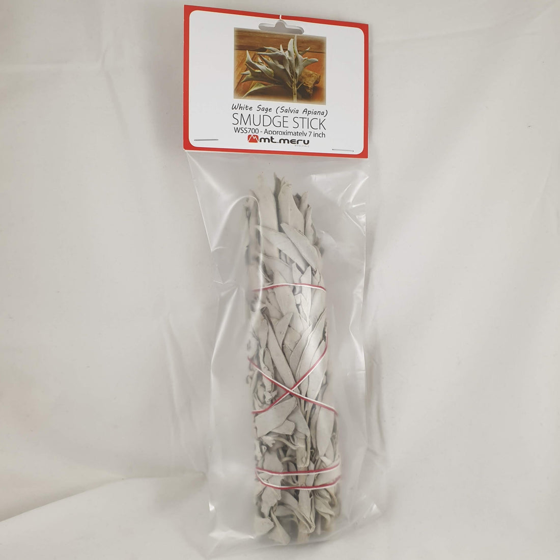 White sage smudge stick tied with red and white string in a clear bag with a Salvia apiana label