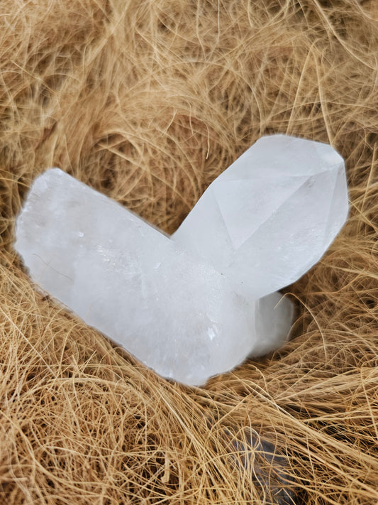Natural clear quartz cluster set on straw