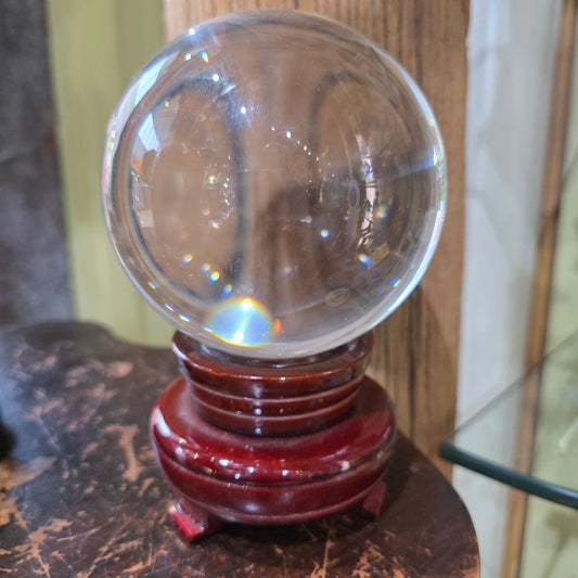 Large clear crystal ball resting on its display stand