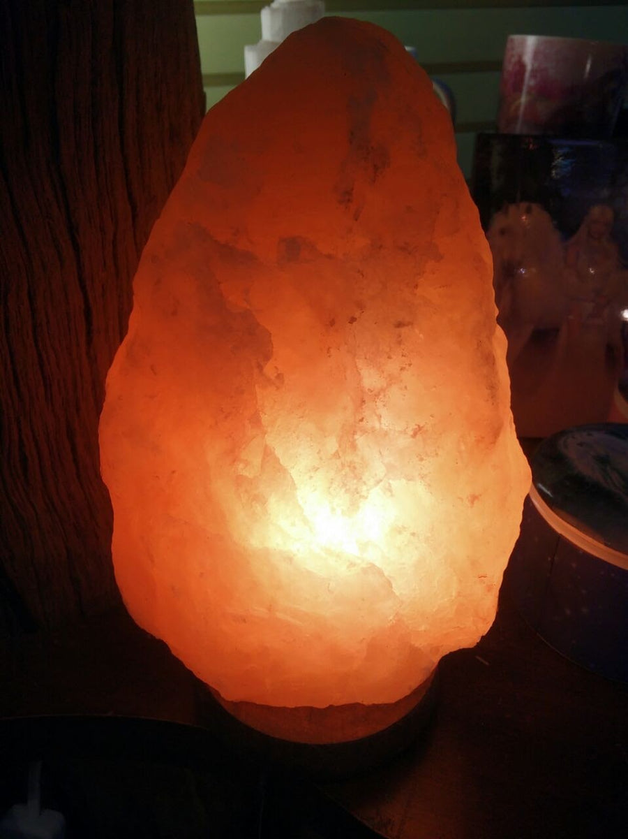 Warm amber Himalayan salt lamp glowing on a shelf