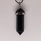 Close-up of a polished black obsidian point pendant on a waxed cord