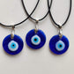 Three handmade blue glass evil eye necklaces showing natural variation